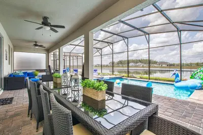 a patio with a swimming pool and a pool house at Storey Lake 8 Bed Lake Front Pool Spa - 1684Str in Kissimmee