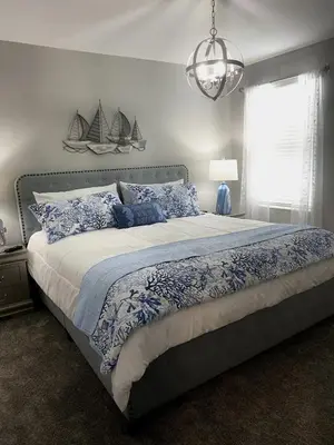 a bedroom with a large bed with blue and white pillows at Beautiful Brand New Waterfront Retreat!1689St in Kissimmee