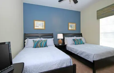 a bedroom with two beds and a blue wall at Paradise Palms- 5 Bed Townhome Wsplashpool-3020Pp in Kissimmee
