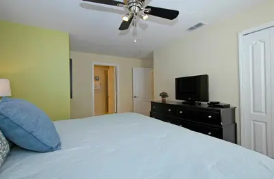 a bedroom with a bed with a ceiling fan and a television at Paradise Palms- 5 Bed Townhome Wsplashpool-3020Pp in Kissimmee