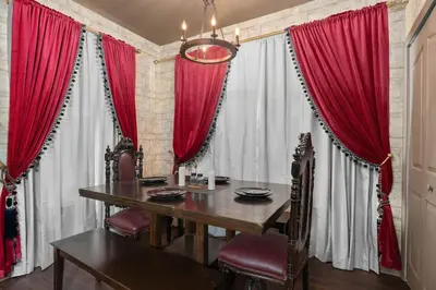 a dining room with a table and red curtains at Harry's Hangout at Legacy Dunes - Sage Vacations in Kissimmee