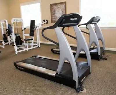 a gym with three treadmills and a treadmill at Harry's Hangout at Legacy Dunes - Sage Vacations in Kissimmee