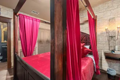 a bedroom with a canopy bed with red curtains at Harry's Hangout at Legacy Dunes - Sage Vacations in Kissimmee