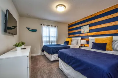 a bedroom with two beds with blue and yellow sheets at Modern Decor, Waterview With Splashpool, Bbq 1636Str in Kissimmee
