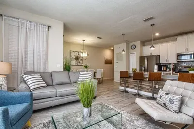 a living room with a couch and a kitchen at Modern Decor, Waterview With Splashpool, Bbq 1636Str in Kissimmee