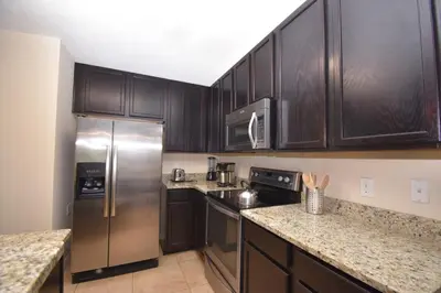 a kitchen with wooden cabinets and a stainless steel refrigerator at Family Friendly Home W Game Room 1705Vp in Kissimmee