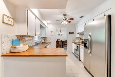 a kitchen with white cabinets and a stainless steel refrigerator at Private Outdoor Oasis with Pool Home in Longwood! in Orlando