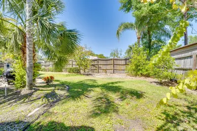 a yard with a fence and palm trees at Private Outdoor Oasis with Pool Home in Longwood! in Orlando