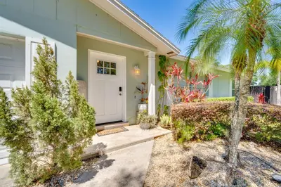 a house with a palm tree and a white door at Private Outdoor Oasis with Pool Home in Longwood! in Orlando