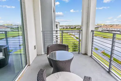 a balcony with two tables and a view of the water at Cozy Apartment 03 Bedrooms at Storey Lake Resort in Kissimmee