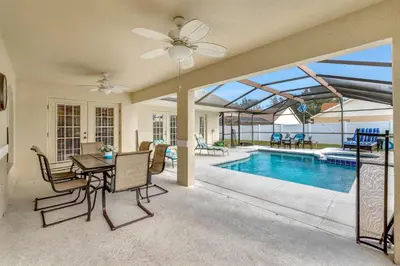a house with a pool and a table and chairs at Anthea's Disney Vacation Home in Orlando