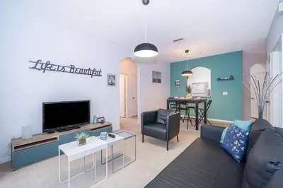 a living room with a couch and a tv at Beautiful Resort 3 Bedrooms Condo Near Disney in Kissimmee