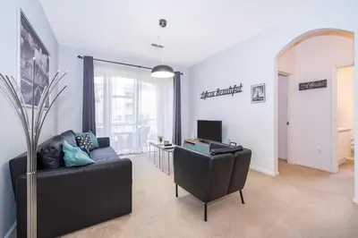 a living room with a black couch and a desk at Beautiful Resort 3 Bedrooms Condo Near Disney in Kissimmee