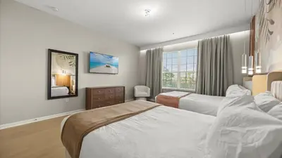 a hotel room with two beds and a window at Upstay Spacious 3BR Home w Patio Vista Cay Resort in Orlando
