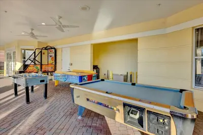a room with a pool table and two tables at Upstay Spacious 3BR Home w Patio Vista Cay Resort in Orlando