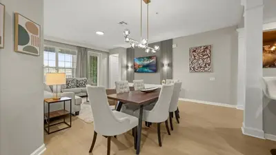 a dining room and living room with a table and chairs at Upstay Spacious 3BR Home w Patio Vista Cay Resort in Orlando