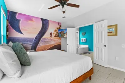 a bedroom with a bed with a painting on the wall at *Sun Palm Paradise* | Sleeps 14 | Near Disney! in Kissimmee