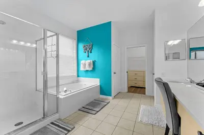 a bathroom with a tub and a shower and a sink at *Sun Palm Paradise* | Sleeps 14 | Near Disney! in Kissimmee