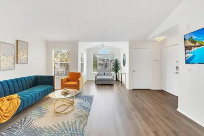 a living room with a blue couch and a chair at Elegant and cozy 2 BD condo near Disney in Kissimmee