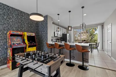 a living room with a foosball table in front of a game at 3 Bedrooms 35 Bathrooms Vista Cay 4845-148 in Orlando