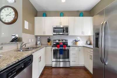 a kitchen with white cabinets and a stainless steel refrigerator at Outstanding 4 bdr near Disney 16108 in Kissimmee