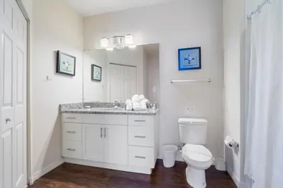 a bathroom with a toilet and a sink and a mirror at Outstanding 4 bdr near Disney 16108 in Kissimmee
