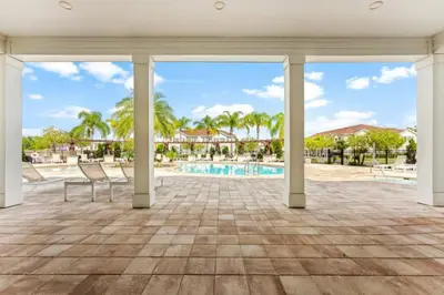 a large patio with chairs and a swimming pool at New 4BDR House near Disney 8979 in Kissimmee