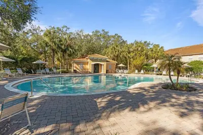a swimming pool with chairs and a house at Family House near Disney - 5109 in Kissimmee