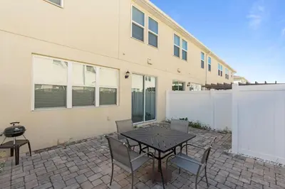 a patio with a table and chairs in front of a building at Family House near Disney - 5109 in Kissimmee