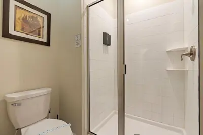 a bathroom with a toilet and a glass shower door at Amazing 5Bdr House with pool 4857 in Kissimmee