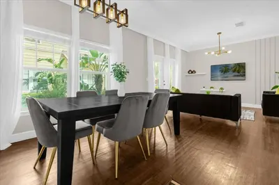 a dining room with a black table and chairs at Luxury 4BDR House close to Parks in Kissimmee