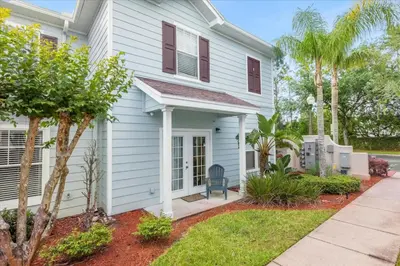 a white house with a porch and a yard at Luxury 4BDR House close to Parks in Kissimmee