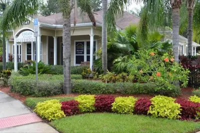a house with a garden of flowers in front of it at Luxury 4BDR House close to Parks in Kissimmee
