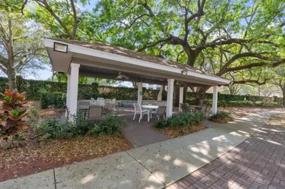 a pavilion with a table and chairs on a sidewalk at Luxury 4BDR House close to Parks in Kissimmee