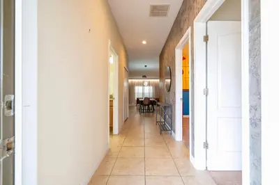 a hallway with white walls and a tile floor at Paradise renovated 5 BD walk to clubhouse 8935 in Kissimmee