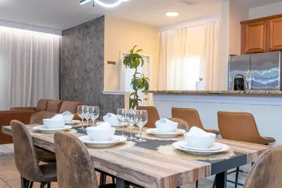 a dining room with a wooden table and chairs at Paradise renovated 5 BD walk to clubhouse 8935 in Kissimmee