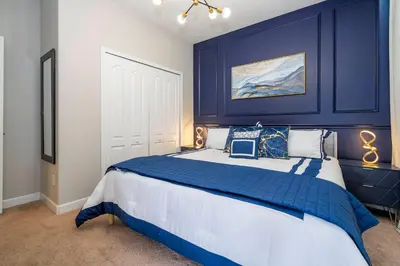 a bedroom with a large bed with blue walls at Paradise renovated 5 BD walk to clubhouse 8935 in Kissimmee