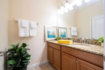 a bathroom with a sink and a large mirror at Paradise renovated 5 BD walk to clubhouse 8935 in Kissimmee