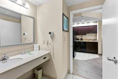 a bathroom with a sink and a large mirror at Hotel Room Next to Universal At Stay Sky Suites in Orlando