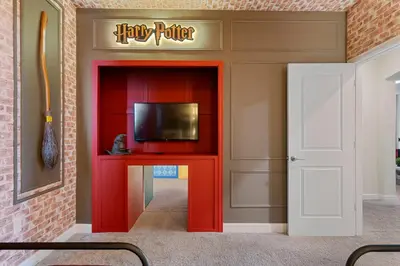 a room with a red partition with a tv and a door at Family 5BR Retreat w Pool Near Disney in Kissimmee
