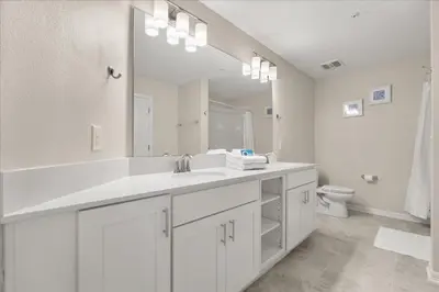 a white bathroom with a sink and a toilet at 3 Bedrooms 2 Bathrooms Storey Lake 3180-308 in Kissimmee