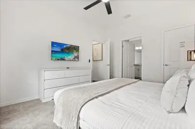 a white bedroom with a white bed and a dresser at 4 Bedrooms 3 Bathrooms Lucaya Village 19-104 in Kissimmee