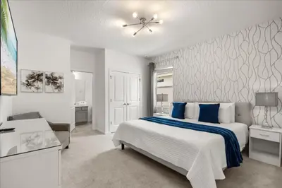 a bedroom with a large white bed with blue pillows at 15 Bedrooms155 Bathroomsveranda Palms 2477Rd in Kissimmee