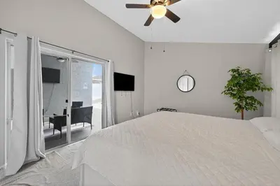 a white bedroom with a bed and a ceiling fan at Entire Disney Retreat Home minutes from Disney, Shopping, and Restaurants 4br,2ba,7beds sleeps 10 in Orlando