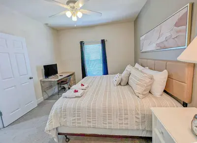 a bedroom with a bed with a ceiling fan and a desk at Perfect vacation spot near Disney 7105 in Kissimmee