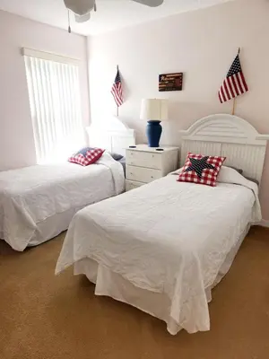two beds in a bedroom with american flags on the wall at Home Away From Home in Kissimmee
