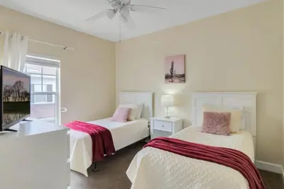 a bedroom with two beds and a tv and a window at Cozy 4BR Disney vacation Home7-104 in Kissimmee