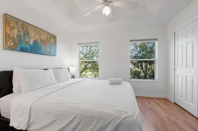 a white bedroom with a bed and two windows at Cozy 3BDR House near Disney - AL in Orlando