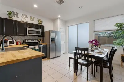 a kitchen with a table and chairs and a kitchen with a kitchen at Cozy 3BDR House near Disney - AL in Orlando