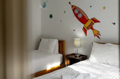 a bedroom with two beds and a rocket on the wall at Cozy 3BDR House near Disney - AL in Orlando